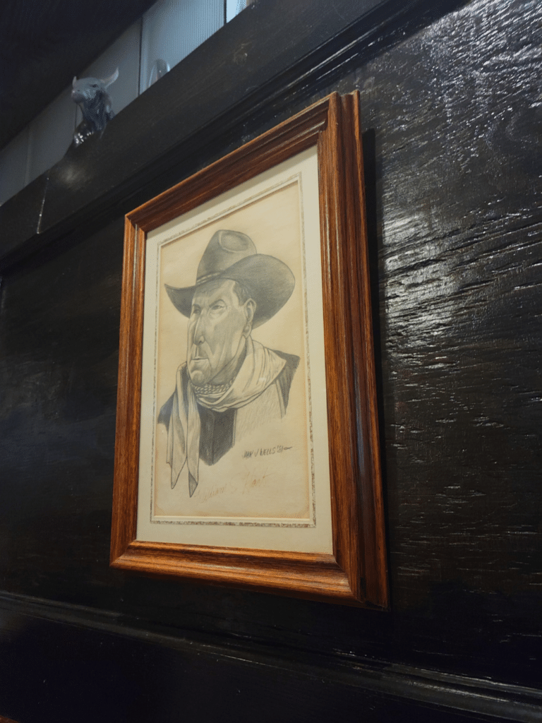 Framed drawing of a cowboy on the wall of a steak house